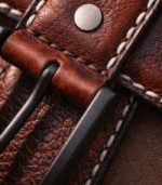 Close-up of hand-stitched Moroccan leather belt showing Berber geometric pattern and waxed thread