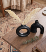Close-up of black ceramic vase surface showing matte glaze texture and handcrafted finish