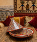Traditional Moroccan ceramic tagine with hand-painted red and yellow geometric pattern