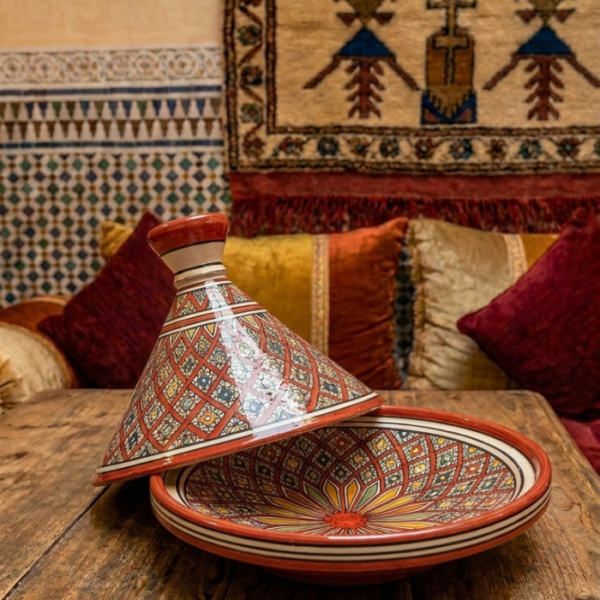 Traditional Moroccan ceramic tagine with hand-painted red and yellow geometric pattern