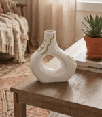 Cream ceramic vase with sculptural cut-out design and sage green hand-painted details