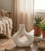 Cream ceramic vase with sculptural cut-out design and sage green hand-painted details