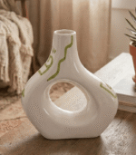 Cream ceramic vase with sculptural cut-out design and sage green hand-painted details