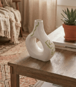 Cream ceramic vase with sculptural cut-out design and sage green hand-painted details